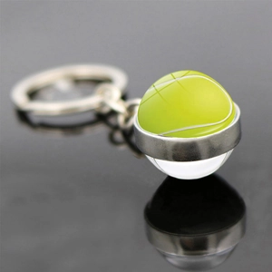 Makro-Detail des Tennisball-Schlüsselanhängers mit Glaskuppel und silbernem Metallring