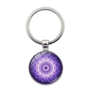 Detailed close-up of a purple mandala pattern glass dome pendant on a silver keychain