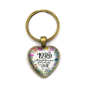 Détail du porte-clés cœur en bronze vintage avec motif fleuri et texte motivant