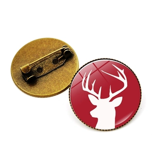 Detailed front and back view of a red stag brooch with a bronze metal safety pin