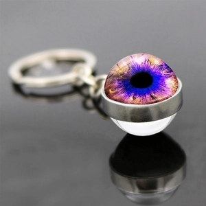Macro view of evil eye glass ball keychain with purple pupil on metal base