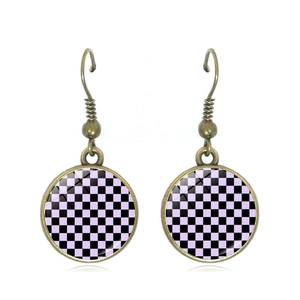 Detail of vintage checkerboard earrings with purple and black pattern under domed glass