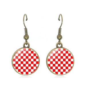 Vintage bronze drop earrings with red checkerboard pattern under clear glass cabochon