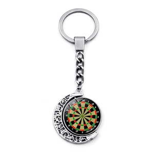 Detail of a rotating silver dartboard keychain with colorful dial and moon-shaped frame