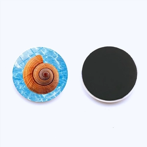 Detail of 25mm ocean snail fridge magnet with blue water pattern and magnetic back