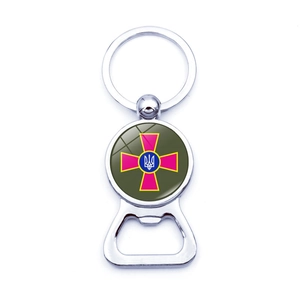 Polished silver bottle opener keychain with a green emblem and trident crest detail