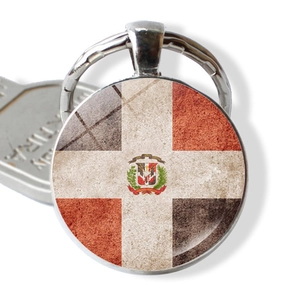 Detailed close-up of Dominican Republic flag keychain pendant with circular glass cabochon