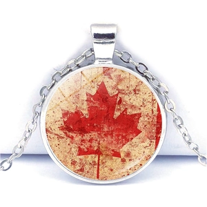Detailed close-up of a vintage Canadian flag necklace with maple leaf glass cabochon