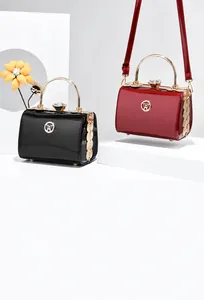 Detail view of glossy patent leather handbags with metal ring handles and gem clasps