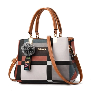 Women's plaid tote bag with top handles, crossbody strap, and plush ball charm