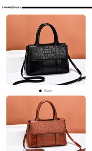 Detalle de un bolso negro con relieve de cocodrilo y correa de hombro ajustable para mujer
