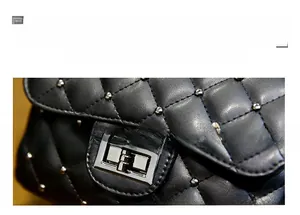 Detail of black quilted PU leather bag with silver studs and rectangular metal twist lock
