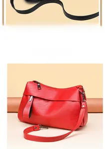 Detail der roten Tasche aus weichem Leder mit silbernen Reißverschlüssen und Gurt