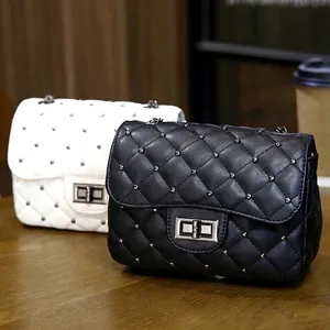 Quilted crossbody bag with metallic studs and chain strap in black and white leather