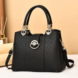 Klassische Handtasche aus schwarzem Leder mit goldener Herzverzierung und Schultergurt