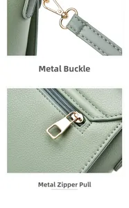 Détail du fermoir mousqueton doré et de la fermeture éclair sur un sac en cuir vert