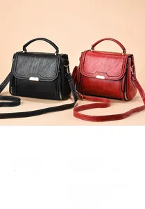 Detail of wrinkle-textured PU leather handbags in black and burgundy with metal zippers
