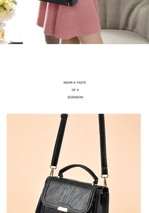 Close-up detail of black leather handbag with gold metal clasp and top handle for women
