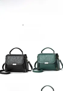 Detail of vintage tote bag in black and green with pleated texture and gold hardware