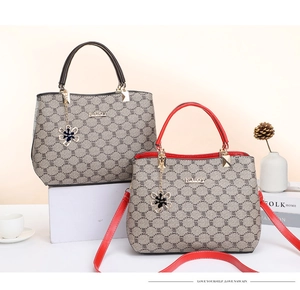 Detail view of two large tote bags with MFX pattern, floral charm and red shoulder strap