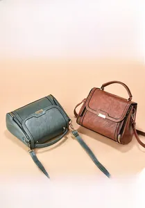 Detail of vintage mini crossbody bags in green and brown with magnetic snap closure