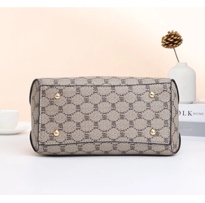 Detail view of large handbag bottom featuring MFX monogram and gold metal feet studs