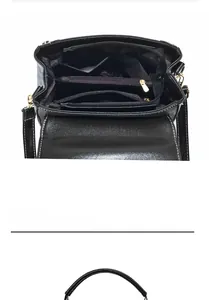Detail view of the black leather handbag's multi-compartment interior with golden zippers