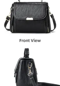 Detail of black pebbled leather handbag with gold hardware zippers and adjustable strap