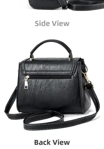 Detail view of black handbag with white contrast stitching and gold metal hardware