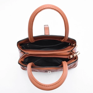 Vue de dessus du sac à main matelassé marron montrant les compartiments zippés et dorés