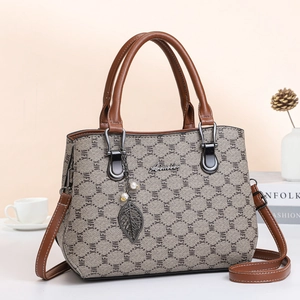 Brown monogram tote bag with gold leaf pendant and adjustable shoulder strap for women