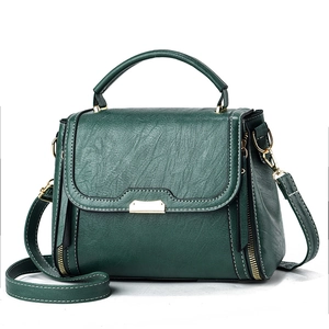 Dark green faux leather crossbody bag with white stitching and gold hardware accents