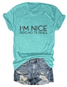 Flat lay of aqua slogan T-shirt with I'M NICE PERO NO TE PASES text and denim shorts