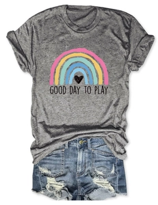 Dettaglio della t-shirt grigia con stampa arcobaleno, scritta Good Day To Play e shorts