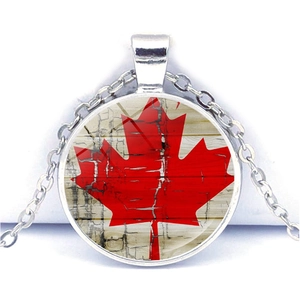 Canada flag necklace with red maple leaf pendant on vintage wood texture and silver chain