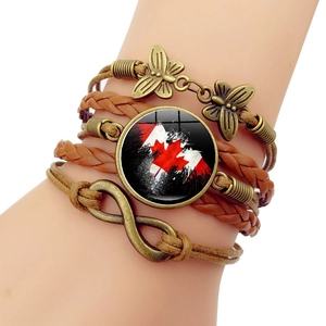 Détail du bracelet multicouche en cuir avec cabochon drapeau canadien et charmes papillon