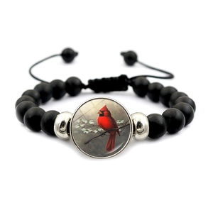 Detail of adjustable black beaded bracelet with cardinal bird glass charm pendant