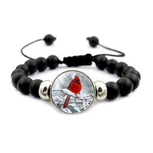 Black matte beaded bracelet with red cardinal glass pendant and adjustable cord