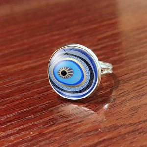 Macro side view of Turkish evil eye ring with blue glass dome and silver band