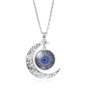 Nahaufnahme des hohlen silbernen Mondanhängers mit blauem Evil Eye Mandala-Charm