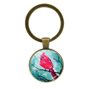 Détail du porte-clés oiseau cardinal avec cabochon en verre et métal couleur bronze