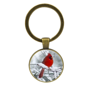 Porte-clés en bronze avec cardinal rouge sur branche enneigée sous dôme en verre