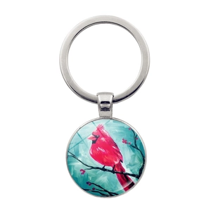 Detailed view of cardinal bird glass cabochon pendant on a silver metal keychain ring