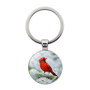 Close-up of glass dome keychain with cardinal bird sitting on a cedar branch