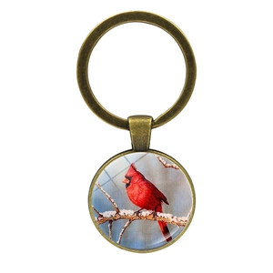 Porte-clés vintage en bronze avec pendentif en verre oiseau cardinal sur fond blanc