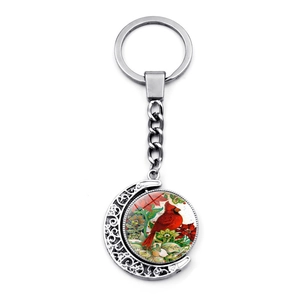 Detailed view of the rotating crescent moon pendant with red cardinal glass gem and filigree