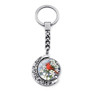 Detailed view of the rotating double-sided cardinal bird pendant on a silver keychain