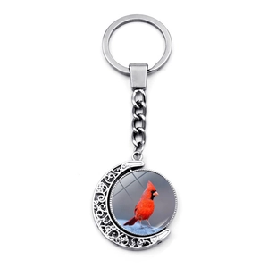 Detail of silver moon-shaped keychain with double-sided rotating red cardinal charm