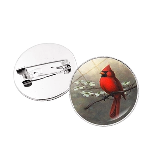 Detailed view of the front and back of a cardinal bird time gem brooch with metal pin
