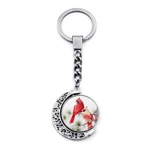 Rotating red cardinal bird keychain with crescent moon frame and double-sided glass pendant